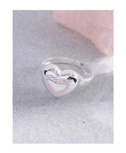 Gros plan d'une bague coeur en argent avec des oxydes de zirconium roses sur fond gris