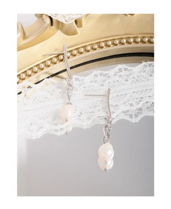 Close-up of S925 silver knotted line earrings with irregular white baroque pearls