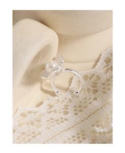 Detail of silver flower earrings with white enamel petals and a central pearl accent