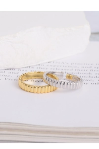 Macro shot of S925 sterling silver gear rings in gold and silver with industrial texture