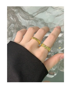 Detail showing two gold plated minimalist rings with wavy and irregular bubble textures