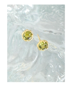 Vue macro de boucles d'oreilles en pierre olive avec monture en argent S925 doré