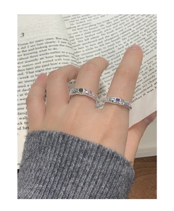 Detail of silver S925 rings with organic texture and colorful zircon heart stones