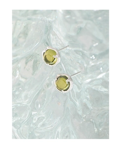 Vue macro de boucles d'oreilles en cristal vert olive avec griffes en argent poli