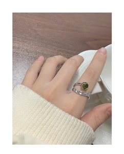 Close-up of S925 sterling silver ring with olive green crystal on a woman finger