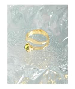 Close-up of S925 silver ring with irregular gold plating and a green crystal stone