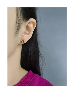 Gros plan sur un clou d'oreille en argent sterling minimaliste avec cristal vert olive texturé