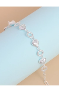 Detail of S925 silver bracelet featuring polished heart charms and twisted chain links