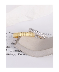 Detailed macro view of gold and silver gear textured rings on a minimalist stone display
