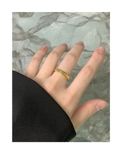 Detail shot of a pleated golden gear-style S925 silver open ring worn on a finger