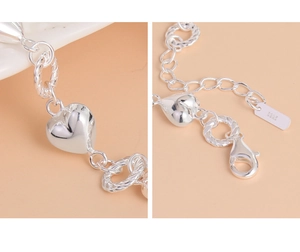 Detailed macro view of S925 sterling silver twist ring bracelet with heart charm