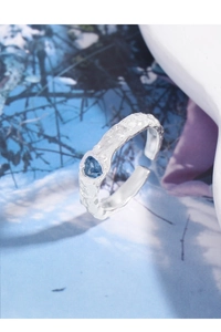 Close-up of S925 sterling silver ring with irregular texture and heart blue zircon