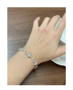 Detail showing the S925 sterling silver twist rope chain with heart link charms on wrist