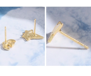 Macro detail of bird and leaf earrings showing S925 silver hallmark and gold finish
