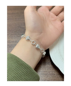Detail of S925 sterling silver heart link bracelet with twisted rope texture rings