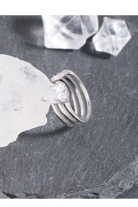 Macro detail of S925 silver triple layer ring with pear cut zircon on rock texture
