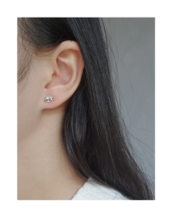 Close-up of S925 sterling silver asymmetrical bird stud earring on model ear