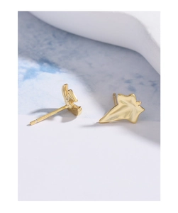 Detailed close-up of S925 silver asymmetric golden leaf earrings with realistic textures
