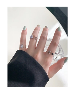 Detail of silver S925 stacking rings featuring teardrop zircon and celestial moon charms