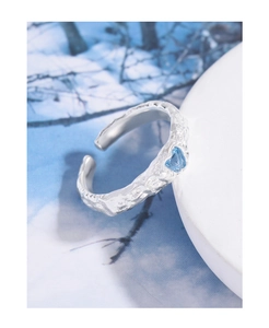 Macro shot of silver lava textured ring featuring a heart-shaped blue zircon stone