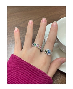 Détail des bagues en argent S925 avec zircons colorés portées à la main par le modèle