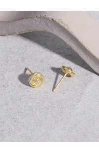 Close-up of golden S925 sterling silver twisted knot earrings with a polished round bead