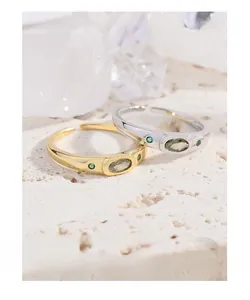Macro detail of gold and silver open rings with oval yellow and green gemstones