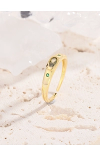 Detail view of gold adjustable ring featuring an oval olive green zircon with bezel setting