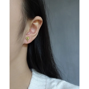 Minimalist S925 silver leaf earrings in gold finish worn by model on a neutral background