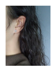 Close-up of S925 sterling silver twisted spiral rose stud earring on model's ear