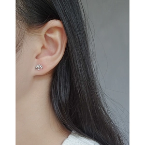 Minimalist S925 sterling silver bird stud earring worn by a model in a side view photo