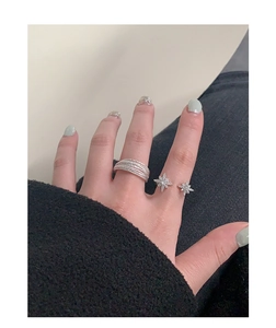 Close-up of S925 sterling silver starburst zircon rings worn on a woman's fingers