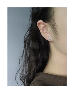 Close-up of minimalist S925 sterling silver spiral stud earrings on female ear lobe