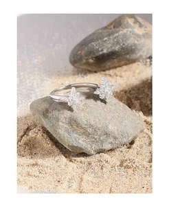 Macro shot of silver S925 star ring with sparkling zircons on natural stone background