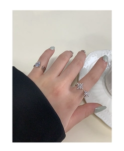 Close-up of S925 silver star and heart rings with zircons on a decorative plate