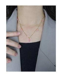 Detail of pink agate double bead pendant on gold 925 silver chain necklace on neck
