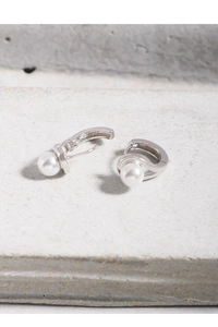 Vue détaillée des boucles d'oreilles en argent S925 et perles sur texture pierre