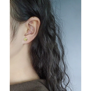 Minimalist S925 sterling silver golden rose flower stud earrings worn by a female model