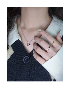 Dettaglio della collana con luna e cuore in argento sterling S925 indossata su un abito