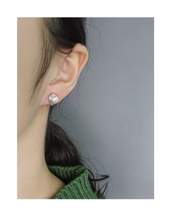 Détail d'une boucle d'oreille en perle et argent S925 portée par un mannequin femme