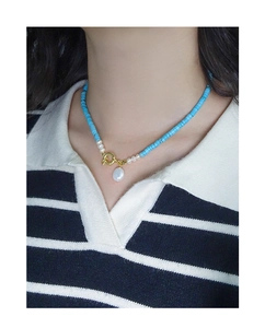 Dettaglio della collana in argento S925 con perle blu e perla barocca indossata dal modello