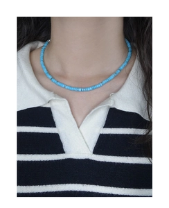 Dettaglio di una collana barocca con perline di turchese blu indossata sul collo