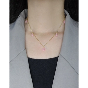Elegant gold necklace with pink agate beads on neck for minimalist feminine jewelry look