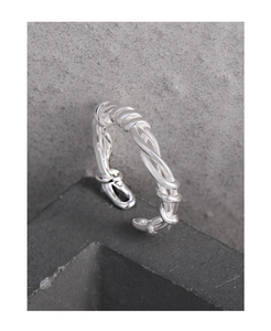 Detailaufnahme des gewebten Rankenrings aus S925 Sterlingsilber auf grauem Stein