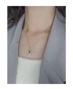 Detail of S925 silver necklace with purple zircon pendant and golden twisted bezel