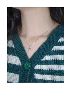 Close-up of minimalist S925 silver starburst pendant necklace on model outfit