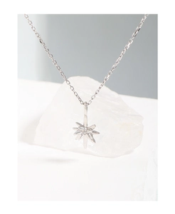 Macro shot of S925 sterling silver star pendant with polished finish on white raw stone