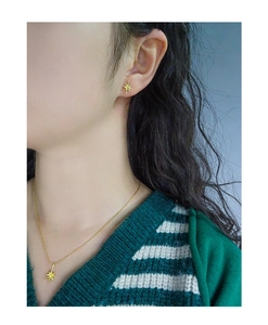 Detailed view of elegant gold starburst pendant necklace and matching stud earrings