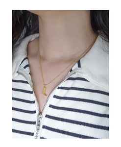 Detailaufnahme einer zarten goldenen S925 Silberkette mit einem Stiefel-Anhänger
