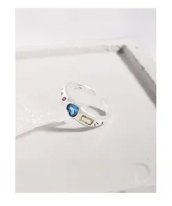 Macro detail of S925 silver adjustable ring with heart-shaped blue and yellow stones